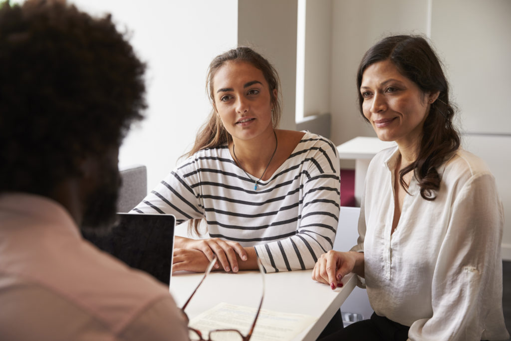 Mother And Daughter Meeting With Male Teacher